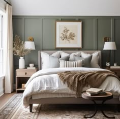 a bedroom with green paneled walls and white linens on the bed, along with two side tables