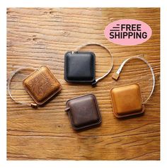 three small leather cases sitting on top of a wooden table with the text free shipping