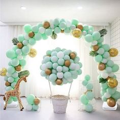 a giraffe standing next to a bunch of balloons