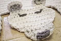 a white crocheted rug with two flowers on it and one is laying on the floor