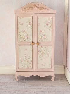 a small pink cabinet with flowers on it in a doll's house or bedroom