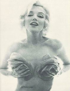 an old photo of a woman with very large breast and gloves on her chest, posing for the camera