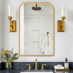 a bathroom sink sitting under a large mirror next to a wall mounted faucet