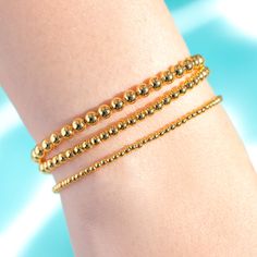 All that glitters is definitely gold when you're wearing our Gold Standard Beaded Bracelet Set. This bracelet set comes with three different bead sizes. Mix and match to show off your best style! Gold Charm Bracelet With Round Beads For Party, Gold Beaded Bracelets For Party With Round Beads, Gold Bracelets With Round Beads For Party, Gold Beaded Bracelets With Tiny Beads For Party, Gold Stretch Bracelet With Round Beads For Party, Gold Bracelets For Party, Trendy Gold Stretch Bracelet With Beads, Gold Bracelets With Tiny Beads For Party, Gold Charm Bracelet With Gold Beads