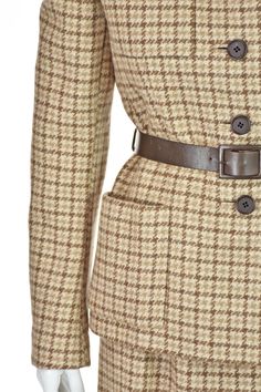 This is a very rare, vintage skirt suit from acclaimed American designer Norman Norell (1900-1972). The union label in this suit was used from 1963-1974, placing it in the mid to late 1960s. The five-button jacket has no collar, four patch pockets, a leather belt, buttoned cuffs, and is lined in silk taffeta. The skirt has a few gathers on each side of the front waistband, making it slighter fuller than a "pencil" skirt. The fabric is a heavy wool houndstooth plaid in varying shades of taupe, ivory and brown. Both pieces are lined in silk taffeta, most of which has been sewn in by hand, as have been the pockets. Based on the measurements, we are estimating it to be about a size 6 or 8. Please refer to the measurements for additional guidance regarding size. JACKET MEAUREMENTS- Shoulder wid Retro Formal Skirt Suit With Buttons, Vintage Wool Tweed Jacket For Office, Vintage Formal Skirt Suit With Button Closure, Vintage Skirt Suit With Button Closure For Formal Occasions, Vintage Skirt Suit With Buttons For Office, Vintage Office Skirt Suit With Buttons, Classic Brown Skirt Suit For Work, Vintage Tweed Long Sleeve Jacket, Vintage Skirt Suit For Semi-formal Fall Occasions