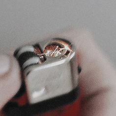 someone holding a lighter in their hand with a ring on it's thumbnail