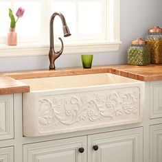 a white kitchen sink sitting under a window