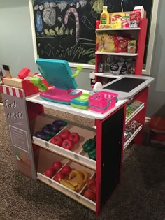 the toy kitchen is set up in front of a chalkboard