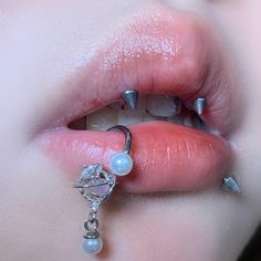 a woman's lips with piercings on them and her tongue hanging off the lip