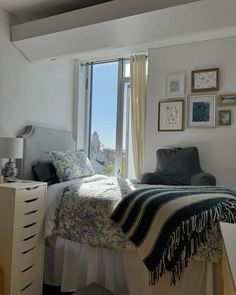 a bedroom with a bed, dresser and large window overlooking the city below it is shown in this image