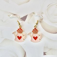 Add some love to your outfit with these adorable Pink Watering Can of Red Hearts Earrings! Each earring features a metal charm shaped like a watering can filled with red hearts, dangling from lead-free, nickel-free hooks. The earrings measure 1 1/2 inches, making them the perfect accessory to add a pop of color and whimsy to any outfit. These earrings are the ideal Valentine's Day accessory to show off your love for fun and festive jewelry. Get your hands on these lovely earrings and spread some love wherever you go! ---Shipping Information--- ✦ Processing time: 3-5 days ✦ Shipping profile: Please check according to the destination. If you have any questions about our products or would like something custom, please reach out! ❤ Thank you for visiting craftcrazyfamilyshop. Follow us to stay Valentine's Day Heart Charm Enamel Earrings, Heart-shaped Metal Earrings For Mother's Day Gift, Enamel Heart Charm Earrings As Gift, Enamel Earrings With Heart Charm As Gift, Valentine's Day Enamel Dangle Earrings, Cute Metal Earrings For Valentine's Day, Red Earrings With Dangling Charms For Gift, Cute Red Enamel Earrings, Valentine's Day Gift Enamel Earrings