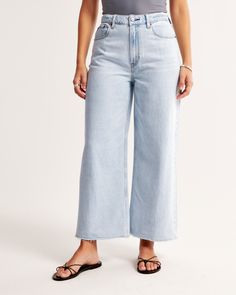 Our Curve Love high rise cropped wide leg jeans in a light wash with a raw-cut hem. This fit features a 10.5” high rise, is relaxed at the waist and hips, and eases into a wide, full-length leg shape with a cropped length. Our Curve Love styles add an additional 2” at the hip and thigh to allow room for your curves and eliminate waist gap. This jean is made from our super light drapey denim fabric, which features a super soft lightweight rigid denim. Cropped Medium Wash Bottoms With Frayed Hem, Trendy Wide Leg Light Wash Cropped Jeans, Trendy Light Wash Wide Leg Cropped Jeans, Spring Cropped Flare Jeans With Frayed Hem, Summer Light Wash Cutoff Flare Jeans, Light Wash Wide Leg Jeans With Frayed Hem, Light Wash Wide-leg Jeans With Frayed Hem, Light Wash Cutoff Cropped Jeans For Summer, Cropped Bottoms With Frayed Hem For Spring