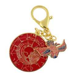 a red and gold plated key chain with a bird on the center, surrounded by stars