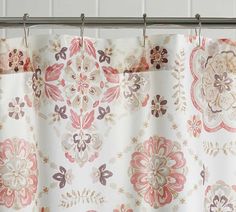 the shower curtain is decorated with pink, brown and white floral designs on it's rod