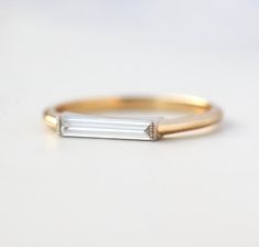 a gold and white diamond ring sitting on top of a table