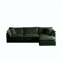 a large green couch with pillows on it's back and one end facing the camera