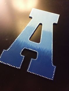 the letters are made out of wood and have beaded trimmings on them