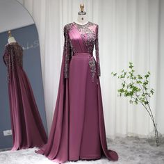 Gorgeous Grape Hue: A rich grape purple color that exudes sophistication and allure, making it an ideal choice for evening events and parties in 2024 . Elegant Silhouette: The dress boasts an elegant silhouette that drapes beautifully, enhancing your natural grace and charm. High Split: A high split in the skirt adds a touch of sensuality and allows for ease of movement, perfect for dancing and making a grand entrance. Luxurious Satin Fabric: The gown is crafted from luxurious satin fabric, adding a touch of sheen and elegance. Ideal for Parties: Tailored for women attending parties and special occasions in 2024 , this gown is designed to captivate and make you feel exquisite at any event. Muslim Formal Dress, Dress For Women Wedding, Formal Dress For Women, Cape Sleeves, فستان سهرة, Cape Dress, Formal Dresses For Women, British Indian, Mozambique