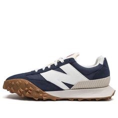 The New Balance XC72 'Navy Gum' is a modern take on a classic design. Inspired by 1970s concept cars, the sneaker features a unique three-traction outsole that gives it a bold, experimental edge. The dark blue, white, and brown colorway is perfect for any activity, from running to walking. The rubber sole provides superior cushioning and stability, making it the perfect choice for any adult. The XC72 is a stylish and innovative sneaker that will take you to the unknown. (SNKR/Retro/Light/Unisex/Low Top) Navy Sports Sneakers With Vibram Sole, Navy Sports Sneakers With Gum Sole, Sporty Navy New Balance Sneakers, Navy Low-top Sneakers For Outdoor, Navy Low-top Outdoor Sneakers, New Balance Navy Running Shoes With Round Toe, Navy New Balance Running Shoes, Navy Outdoor Sneakers With Vibram Sole, New Balance Navy Round Toe Sneakers