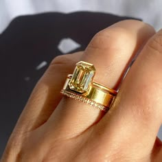 a woman's hand with a yellow diamond ring on top of her left hand