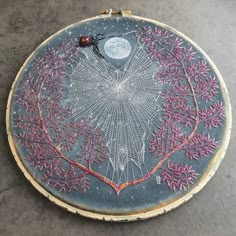 an embroidery project is shown on the floor with a ladybug sitting on it