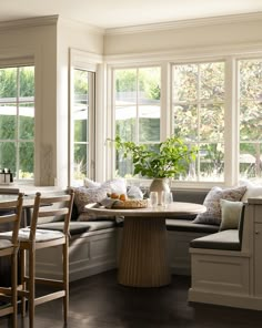 a corner table in the middle of a room with two chairs and a bench next to it