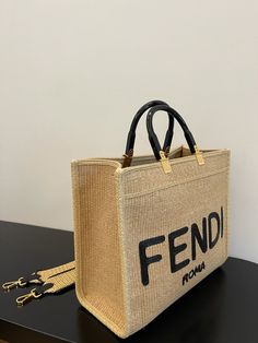 Description FND Sunshine Medium Beige and Black straw shopper Bag For Woman 31cm/12in 8BH386AKRPF1CBX Rep 1:1 Size: 31 x 17 x 35 cm / 12 x 7 x 13.5 inch Medium Sunshine shopper made of natural-coloured woven straw with a moss-stitch effect, with black straw “FND ROMA” embroidery and stiff tortoiseshell-effect plexiglass handles. Features a spacious straw-lined internal compartment, black leather edging and gold-finish metalware. Can be carried by hand or worn on the shoulder thanks to the two ha Fendi Sunshine, Moss Stitch, Beige And Black, Evening Clutch Bag, Shopper Bag, Fendi Bags, Tote Backpack, Cute Bag, Luxury Items