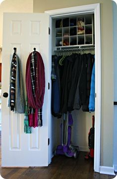 an open closet with clothes hanging on the door