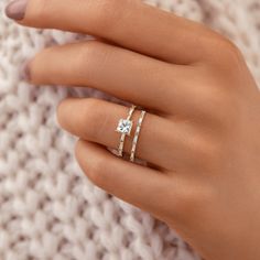 a woman's hand with two rings on top of her finger and the other one has