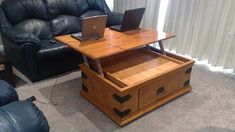 a living room with two couches and a table that has laptops on it