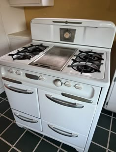 an old fashioned white stove with two burners on the front and one oven door open