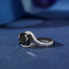 This captivating ring features a mesmerizing swirl design, combining the contrasting beauty of black and white stones. Two ribbons, one lined with black stones, the other with shimmering white stones, twist and swirl together to create the ring's shank. Its unique and contemporary style is sure to turn heads and add a touch of drama to any outfit.Carat Weight: 2.3 ctStone Size: 7 mmStone Type: Jeulia® StoneNumber of Stones: 1 Stone Color: Fancy BlackStone Shape: RoundCarat Weight: 0.798 ctStone Black Jewelry With Center Stone For Anniversary, Black Jewelry For Anniversary, Black Spinel Rings With Diamond Accents, Black Diamond Jewelry With Accent Stones, Black Rings With Diamond Accents And Black Spinel, Black Diamond Rings With Accent Stones, Fine Jewelry Black With Accent Stones, Black Gemstone Ring For Anniversary, Fine Black Jewelry With Accent Stones