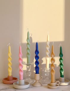 seven candles are lined up on a table