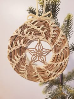 a wicker ornament hanging from a christmas tree