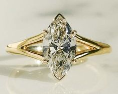 a yellow gold ring with a pear shaped diamond