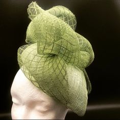 This beautiful Sophia green pillbox hat has a beautifully light sculptural quality and sits on the left side of the head.  It has green crin crafted onto of the shimmery sinnamay base with beading details.    This fully handmade piece uses traditional millinery techniques and is lined with a satin lining and has elastic which sits at the back of the head under the hair.  The elastic can be changed to suit the colour of your hair. Packed in a lovely hat box for safe keeping. Luxury Green Headpiece With Curved Brim, Luxury Curved Brim Green Headpiece, Elegant Green Cloche Hat, Elegant Green Headpiece For Church, Adjustable Green Mini Hat For Wedding, Green Top Hat For Summer Church Events, Elegant Green Top Hat For Party, Elegant Green Church Fascinator, Elegant Green Fascinator For Church