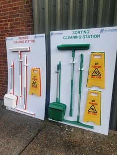 three cleaning station signs with brooms and mop