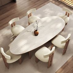 a dining room table with white chairs and a vase on the top, in front of an area rug