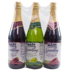 three bottles of sparkling wine with grapes on the bottom and one bottle filled with liquid