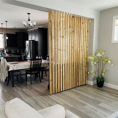 a living room and dining room area with wood slats on the wall, hardwood flooring