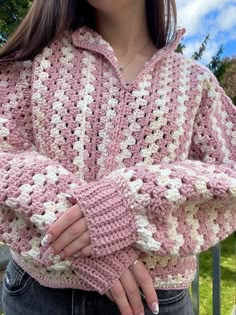 a woman wearing a pink and white crocheted sweater