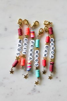 several different colored beads and charms on a marble surface with the words created by hand written in small letters