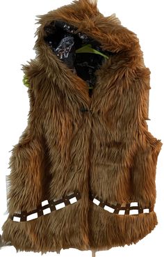 a brown furry vest with holes on the front and sides, attached to a wooden stand