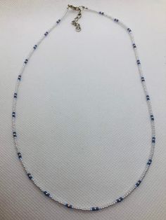 "This beadwork project is a design that is made on nylon coated stainless steel. Different size beads can be used in this design, but this particular one is done with size 11/0 Miyuki glass seed beads. It is not stretchy.  it has a 1\" extension on it. It measures 18.5\" to 19.5\" with extender.  If you would like this bracelet done in a different size or colors, let me know and I'll set up a listing for that.  You are purchasing this actual beaded necklace. Let me personalize some especially for you in your school colors." Adjustable White Beaded Chain, White Beaded Necklace With Round Beads, White Heishi Beads Necklace With Spacer Beads, Handmade White Heishi Beads Jewelry, White Round Heishi Beads Jewelry, White Tiny Beaded Necklaces For Jewelry Making, Blue Minimalist Necklace With Spacer Beads, White Jewelry With Spacer And Round Beads, Blue Minimalist Necklaces With Spacer Beads