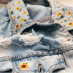 an old jean jacket with sunflowers embroidered on it