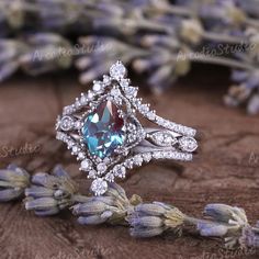 an engagement ring with a blue topazte surrounded by lavender flowers