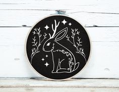 a black and white embroidery hoop with an image of a rabbit