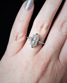 a woman's hand with a diamond ring on it