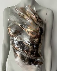 a mannequin is covered with plastic wrap and silver foil, as if it were an abstract piece of art