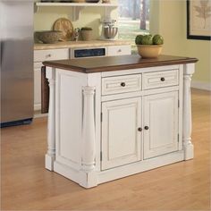 a white kitchen island with wooden top